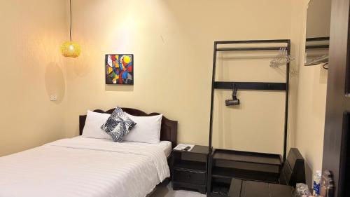 a small bedroom with a bed and a mirror at Lá Hotel in Quang Ngai