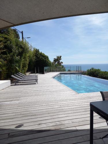 une piscine avec l'océan en arrière-plan dans l'établissement Superbe Villa sur le mont Saint Clair à Sete, à Sète