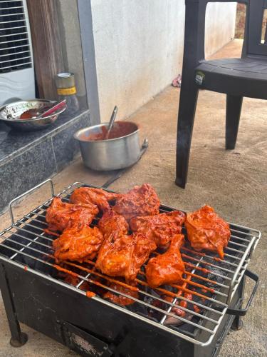 a bunch of chicken cooking on a grill at Anay's Homely Hideout in Davorlim