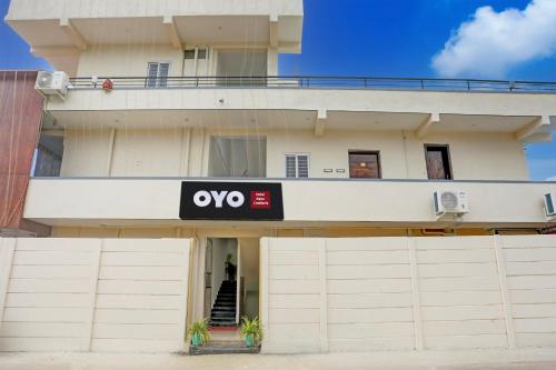 an apartment building with a sign on it at Hotel O Aqua Comforts in Yelahanka