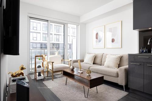 a living room with a couch and a table at Classy and Luxury 2 bedroom apartment 5 mins to Dundas Square in Toronto