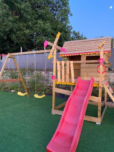 a wooden playground with a slide and swings at Relais Green Paradise in Apice