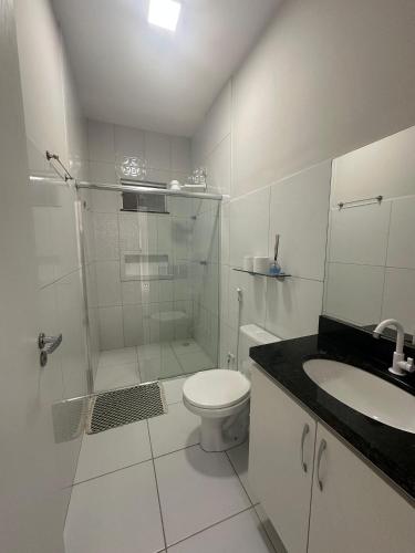 a bathroom with a shower and a toilet and a sink at Casa 100% mobiliada no Caçari in Boa Vista