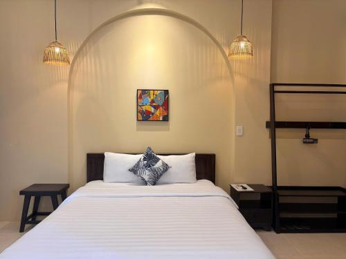a bedroom with a large bed with an arch above it at Lá Hotel in Quang Ngai