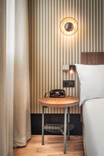 a bedroom with a table next to a bed at Casa de las Artes, member of Meliá Collection in Madrid