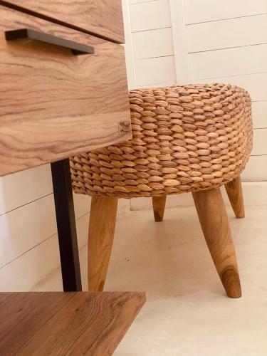 a wooden table with a wicker chair next to a desk at lumbung asmara in Singaraja