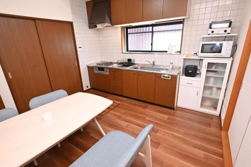 a kitchen with a table and chairs and a sink at Bhome Hikone Jizo in Hikone