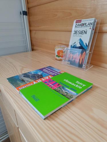 two books sitting on top of a wooden table at Apartament Oravski in Suchá Hora