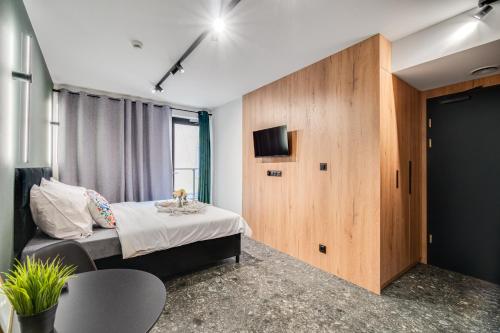 a bedroom with a bed and a tv and a table at Muzealna Residence in Opole