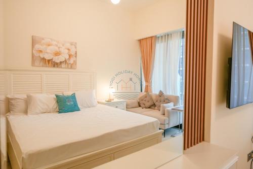 a bedroom with a bed and a couch and a mirror at Yogi - Studio in Azizi Riviera - MBR City & Pool in Dubai