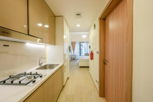 a kitchen with a sink and a stove at Yogi - Studio in Azizi Riviera - MBR City & Pool in Dubai