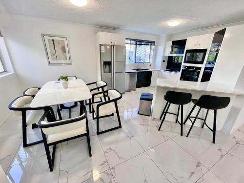 a kitchen with a table and some chairs and a counter at Surfers Paradise Center- Ocean View Vacation Condo-Pool&Pier,Walk to Beach in Gold Coast