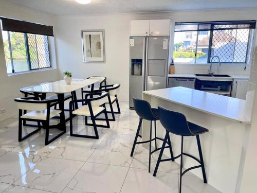 a kitchen with a table and chairs and a refrigerator at Surfers Paradise Center- Ocean View Vacation Condo-Pool&Pier,Walk to Beach in Gold Coast