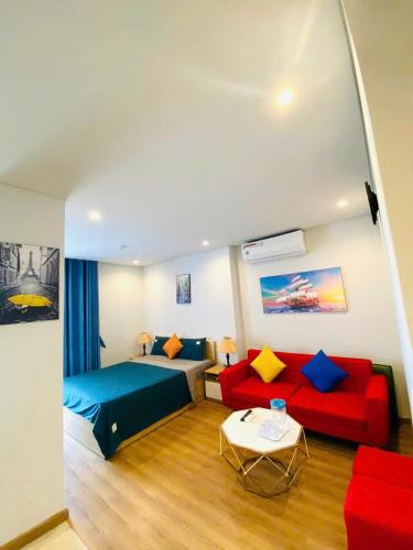 a hotel room with a bed and a red couch at Golden sunshine studio-Sea view &Nelflix Free in Ha Long