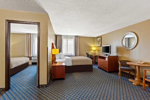 a hotel room with two beds and a television at Quality Inn & Suites in Seville