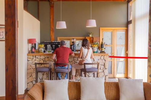 a man and a woman sitting at a bar at Best Western Hotel Santa Caterina in Acireale