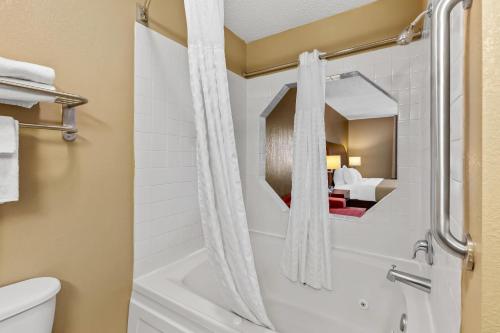 a bathroom with a bath tub and a toilet at Quality Inn & Suites in Seville