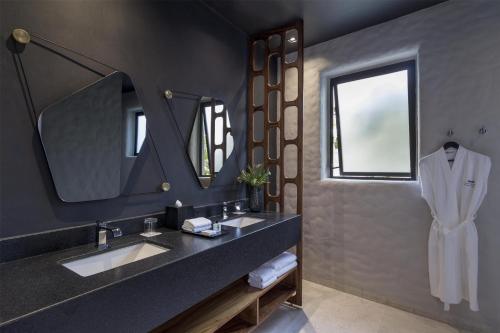 a bathroom with a sink and a mirror at Thompson Zihuatanejo, A Beach Resort, by Hyatt in Zihuatanejo