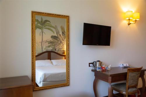 a mirror in a hotel room with a bed and a desk at Best Western Hotel Santa Caterina in Acireale
