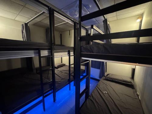 two bunk beds in a room with blue lights at Tong Hao You Shan in Tainan