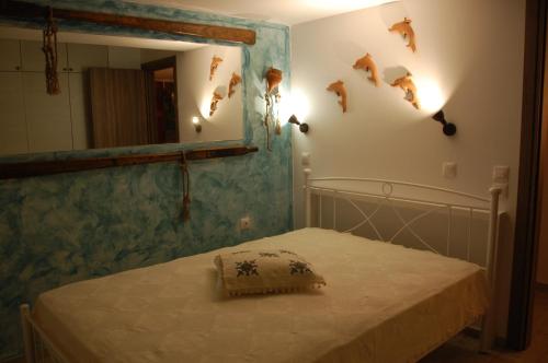 a bedroom with a bed and a mirror with fish on the wall at Aegean Pearl in Áyios Dhimítrios