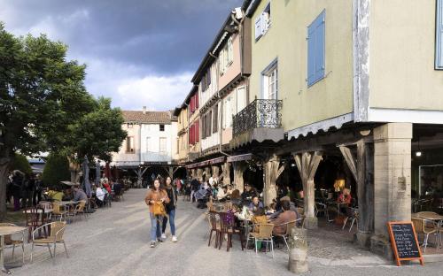 a woman walking down a street with a crowd of people at Cottage 4 personnes in Mirepoix