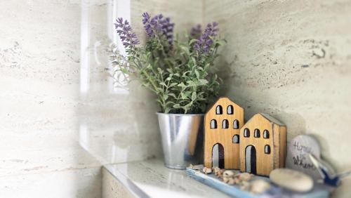 a small house figurine next to a vase with flowers at Stella Maris in Kali