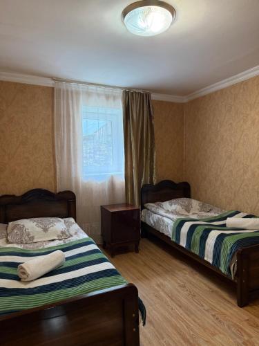 a room with two beds and a window with at Nizharadze's Tower in Ushguli