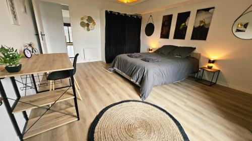 a bedroom with a bed and a table and a desk at T4 spacieux et cosy in Boé