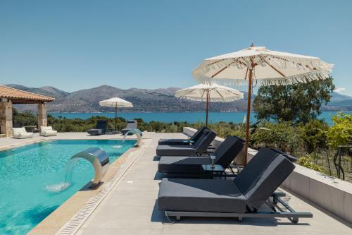 a row of chairs and umbrellas next to a swimming pool at Remenata in Lixouri