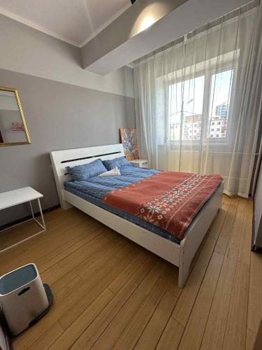 a bedroom with a large bed in a room with a window at The Long White Apartment in Ulaanbaatar