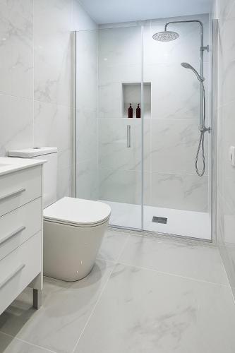 a white bathroom with a shower and a toilet at Apartamento Maresía in Candelaria