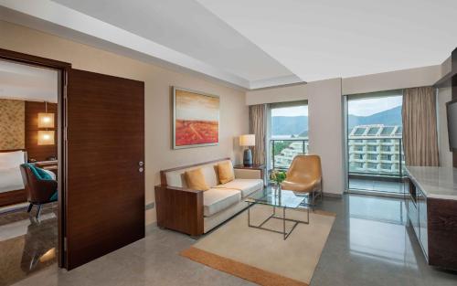 a living room with a couch and a desk in a room at MGM Grand Sanya in Sanya
