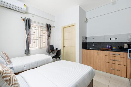 a bedroom with two beds and a kitchen at Wandr Hotel Brookefield, Bangalore in Bengaluru