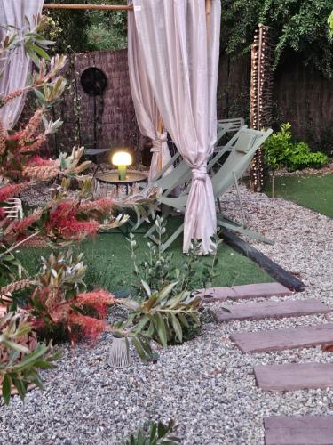 un jardin avec un parasol et une table dans l'établissement Le cabanon de casaOma, à Prunelli-di-Fiumorbo