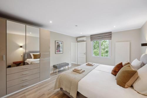 une chambre blanche avec un grand lit et un miroir dans l'établissement Villa Lavyn, à Grimaud