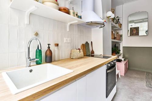 une cuisine avec un évier et un plan de travail dans l'établissement Evangile - Cosy studio avec petite cour privee, à Paris