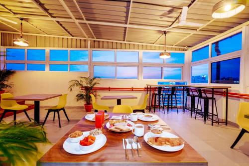 a table with plates of food on it in a restaurant at Wandr Hotel Brookefield, Bangalore in Bengaluru