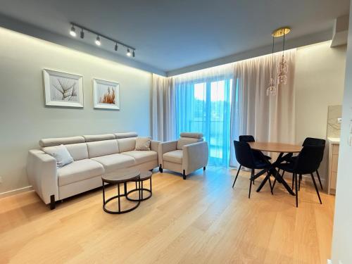 a living room with a couch and a table at Apartamenty Klonova Park in Olecko