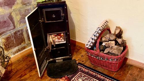 a room with a basket on the floor and a wall at Etno kuća Parče neba in Užice