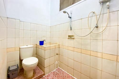 a bathroom with a toilet and a shower at Hotel Garuda RedPartner in Jakarta