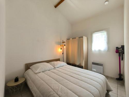 une chambre avec un grand lit et une fenêtre dans l'établissement Charmante maison de vacances, 4P, piscines, proche Gohaud, à Saint-Michel-Chef-Chef