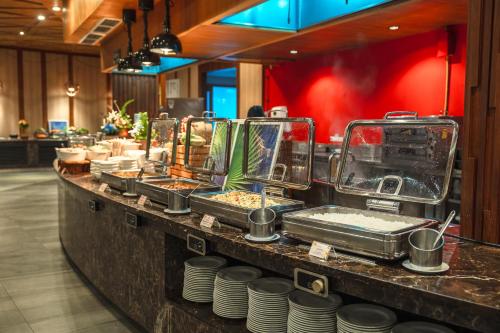 Andaman Pool Villas ,Maikhao في شاطئ ماي خاو: خط بوفيه مع أحواض وأطباق في مطعم