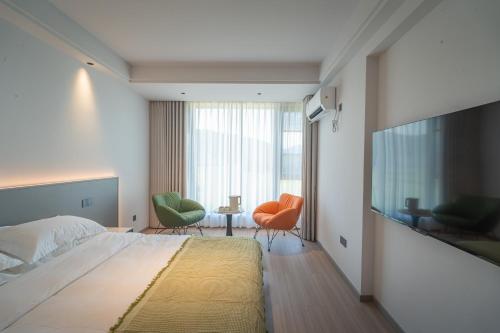a bedroom with a large bed and two chairs at Daishan Mountain and Sea Cloud Homestay Sunrise Seaview Bed and Breakfast in Zhoushan
