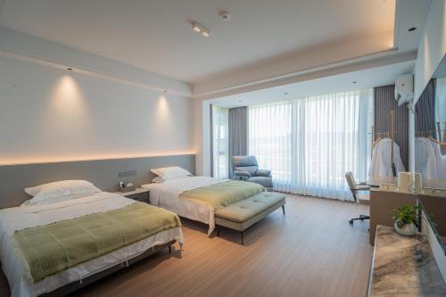 a hotel room with two beds and a chair at Daishan Mountain and Sea Cloud Homestay Sunrise Seaview Bed and Breakfast in Zhoushan