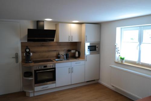 a kitchen with a stove and a sink and a window at Apartment 67 in Bad Neustadt an der Saale