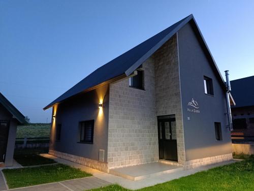 a building with a black roof and a door at Villa Dussi in Žabljak