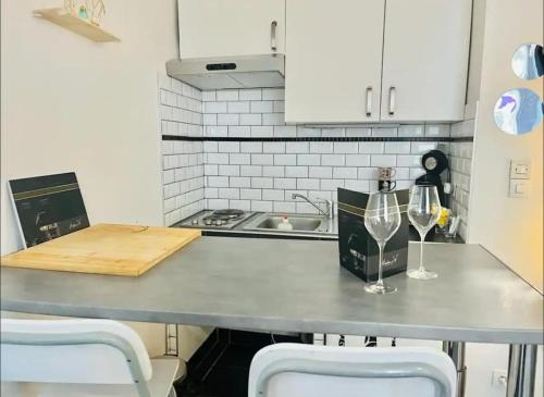- une cuisine avec un comptoir et 2 verres à vin dans l'établissement Coquebert studio confortable proche centre ville, à Reims