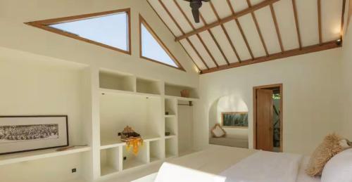 a bedroom with a large bed with a skylight at Villa Maja Bingin Boutique Hotel in Uluwatu