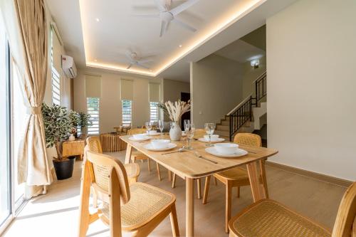 a dining room with a wooden table and chairs at La Ferringhi Villa by BRB in Batu Ferringhi